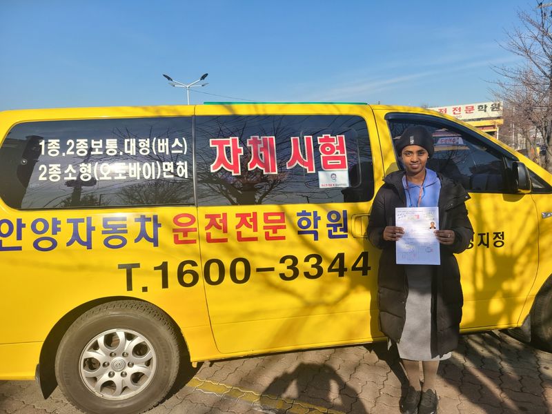 Foreign student holding a newly issued Korean driver's licence at Anyang Driving School