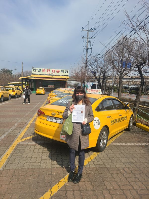 International student celebrating a road driving test pass at Anyang Driving School
